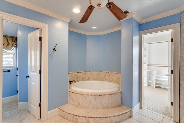 bathroom with tiled tub, tile patterned floors, ornamental molding, and ceiling fan