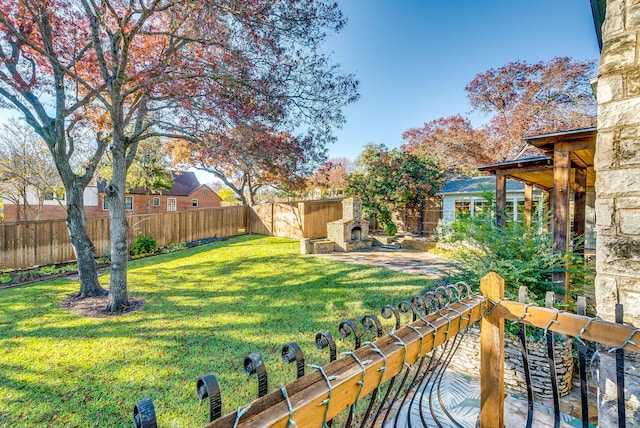 view of yard featuring an outdoor stone fireplace