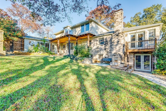 rear view of house with a yard and french doors