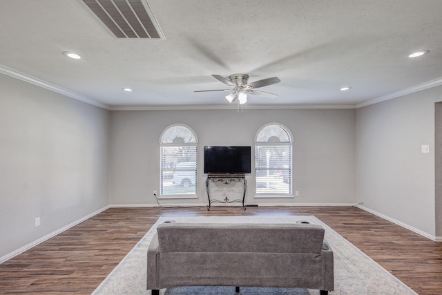 living room featuring hardwood / wood-style floors, ceiling fan, crown molding, and a textured ceiling