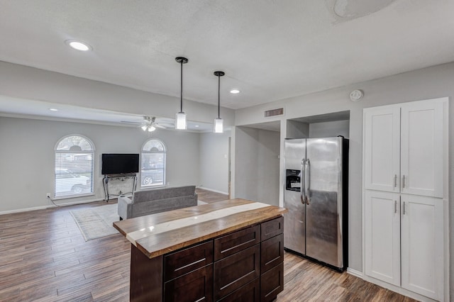 kitchen featuring dark brown cabinetry, ceiling fan, hanging light fixtures, stainless steel fridge with ice dispenser, and light hardwood / wood-style floors