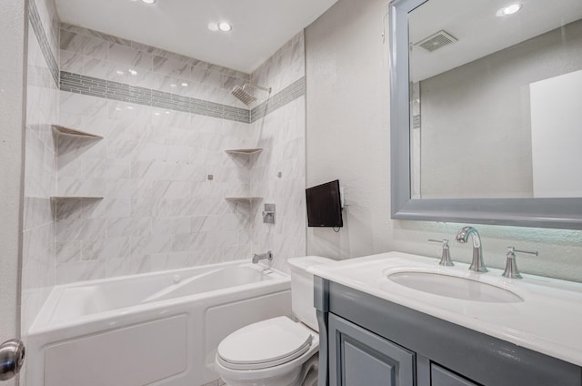 full bathroom featuring vanity, tiled shower / bath combo, and toilet