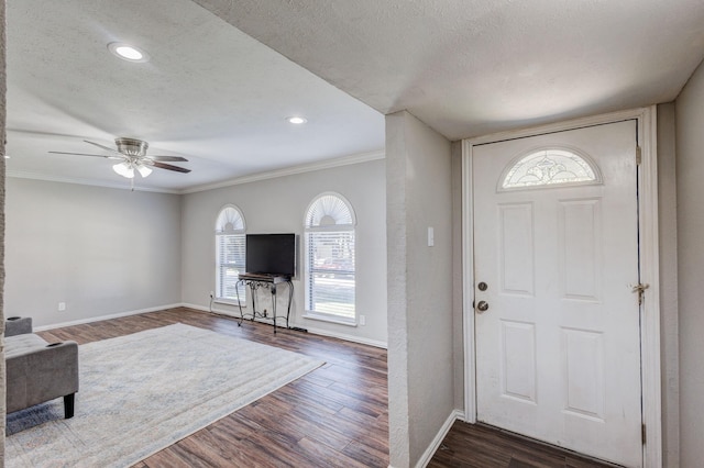 entrance foyer with crown molding, ceiling fan, dark hardwood / wood-style flooring, and a textured ceiling