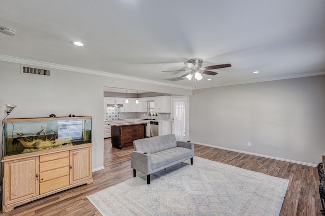 living room featuring ceiling fan, crown molding, and light hardwood / wood-style flooring