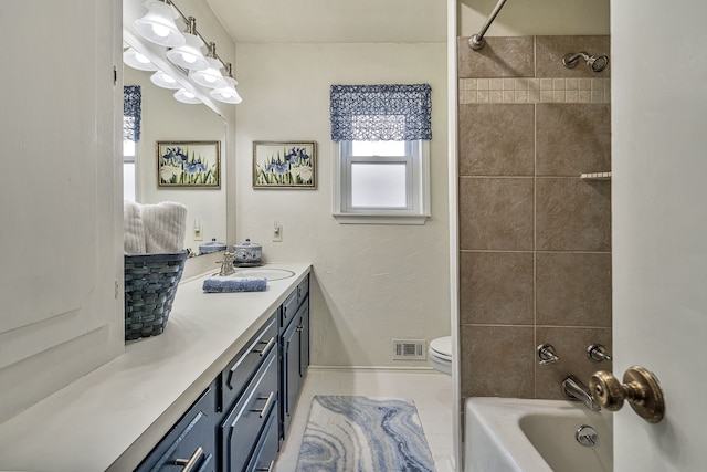 full bathroom with tile patterned flooring, vanity, toilet, and tiled shower / bath combo