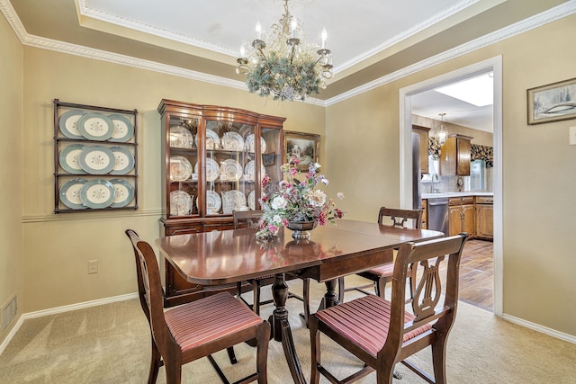 carpeted dining area featuring sink, crown molding, and an inviting chandelier