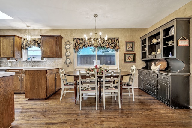 dining area with dark hardwood / wood-style flooring, sink, and an inviting chandelier