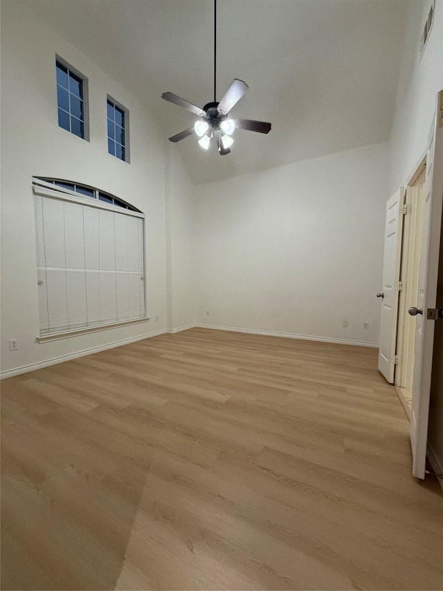 unfurnished bedroom with ceiling fan, high vaulted ceiling, and light hardwood / wood-style flooring