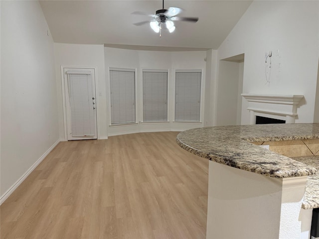 kitchen with ceiling fan, lofted ceiling, and light hardwood / wood-style floors