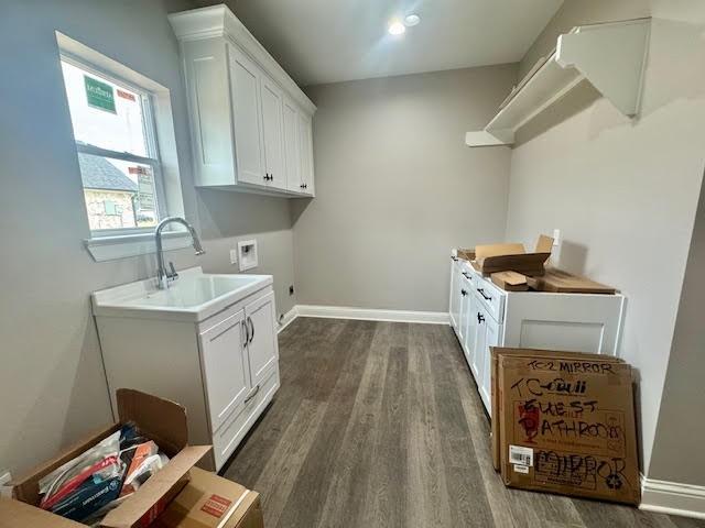 laundry area featuring electric dryer hookup, cabinets, sink, washer hookup, and dark hardwood / wood-style flooring