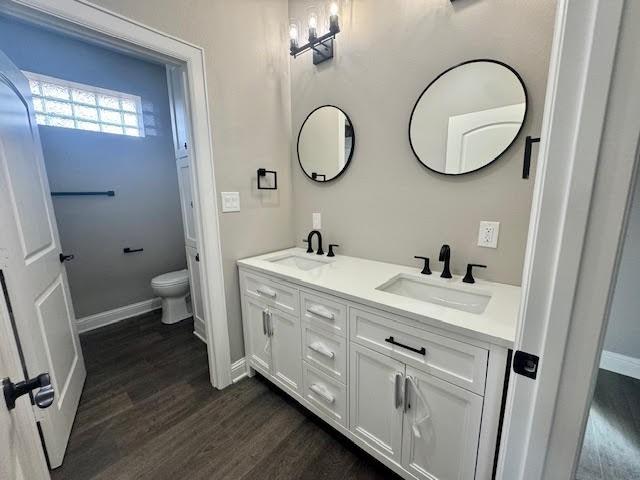 bathroom featuring wood-type flooring, vanity, and toilet