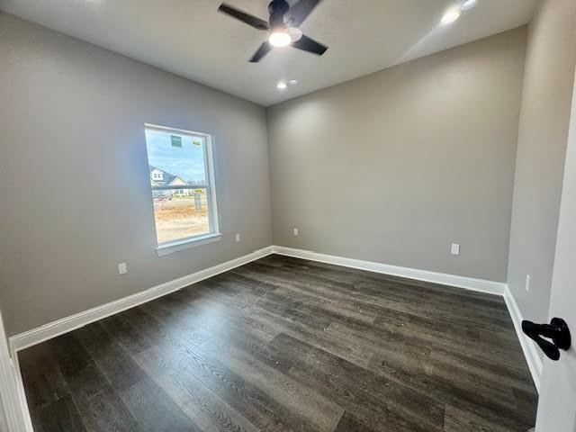 spare room featuring dark hardwood / wood-style flooring and ceiling fan