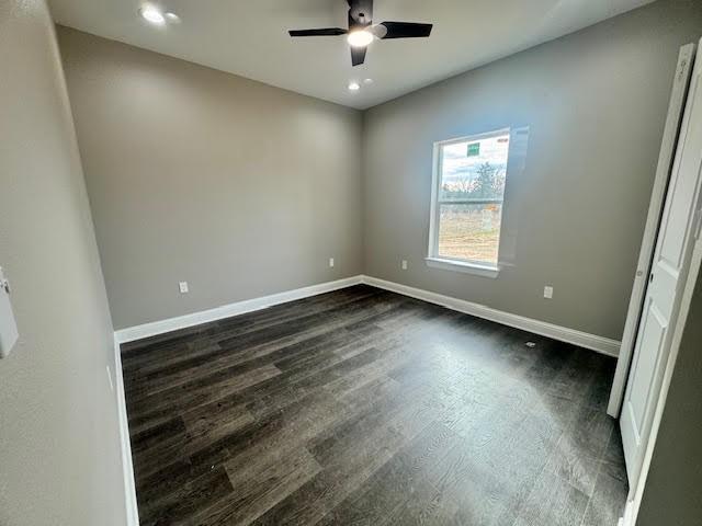 spare room with ceiling fan and dark hardwood / wood-style flooring