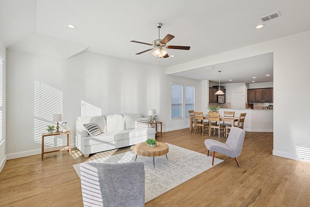 living room featuring light hardwood / wood-style flooring and ceiling fan