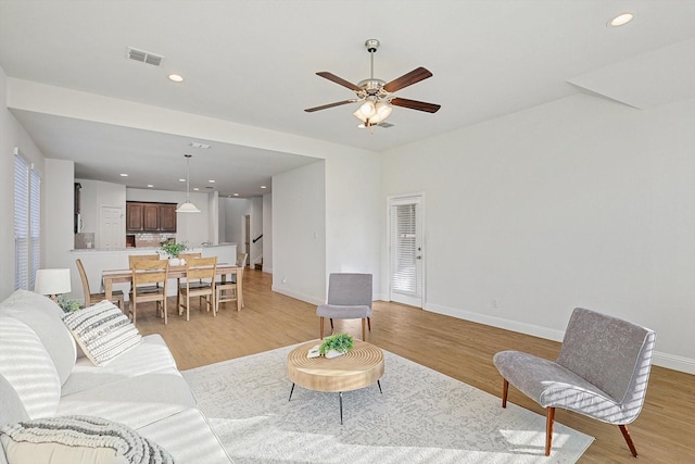 living area featuring recessed lighting, light wood-type flooring, visible vents, and baseboards