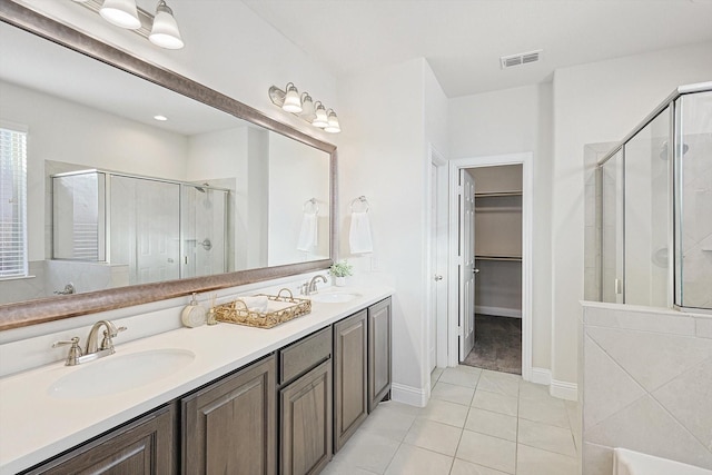 bathroom with tile patterned floors, a shower with door, and vanity