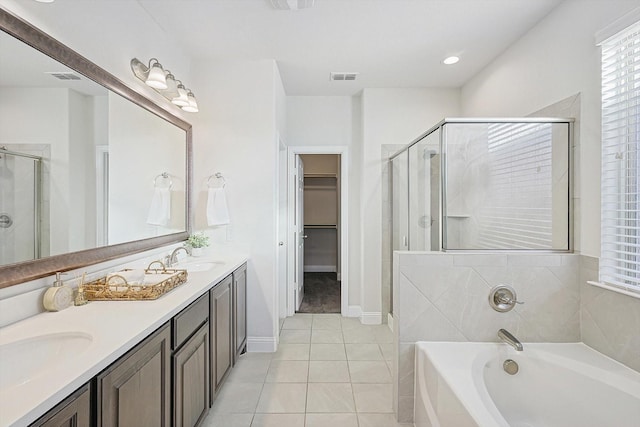 bathroom featuring visible vents, a sink, a spacious closet, and a shower stall