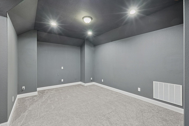 spare room with visible vents, baseboards, carpet, vaulted ceiling, and recessed lighting