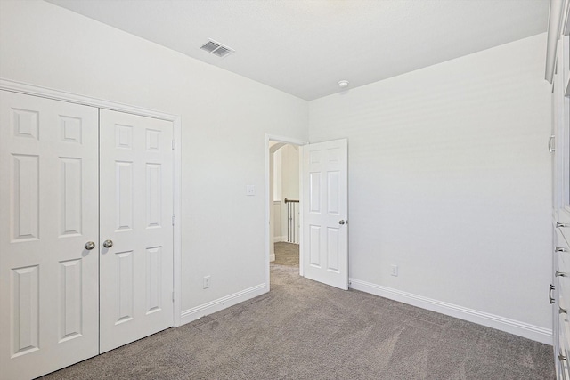 unfurnished bedroom with a closet, baseboards, visible vents, and carpet flooring