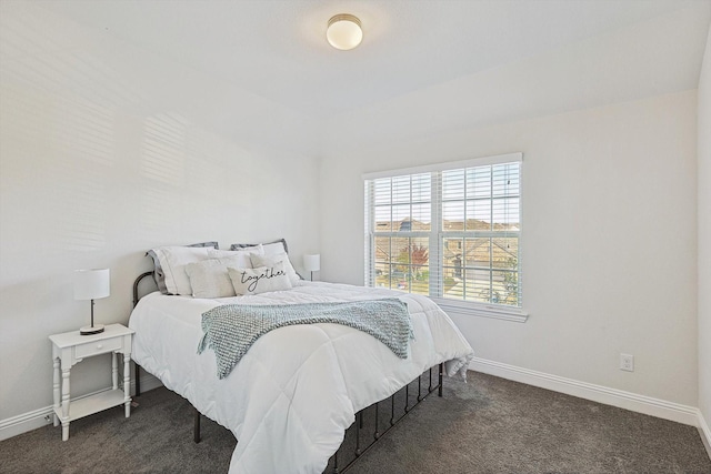 bedroom featuring baseboards and dark carpet