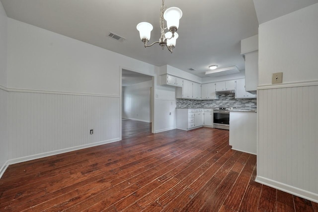 kitchen featuring stainless steel electric range, white cabinets, dark hardwood / wood-style floors, tasteful backsplash, and a chandelier