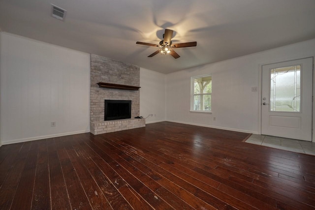 unfurnished living room featuring ceiling fan, a fireplace, and dark wood-type flooring