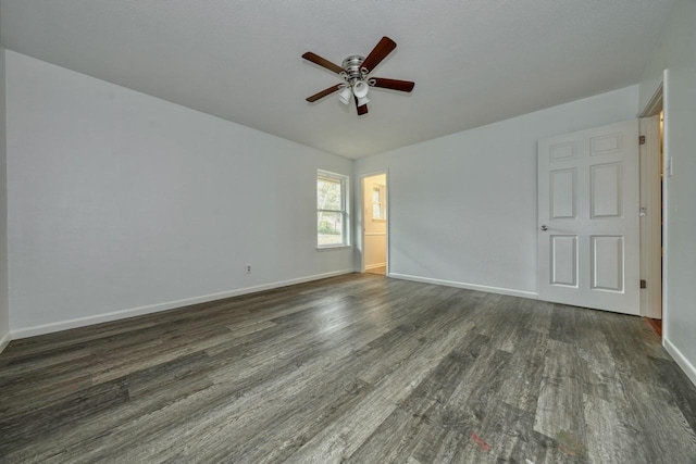 empty room with dark hardwood / wood-style flooring and ceiling fan