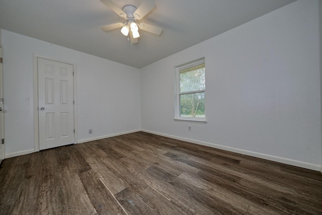 empty room with ceiling fan and dark wood-type flooring