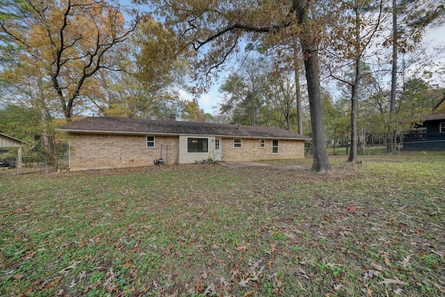 rear view of property featuring a lawn