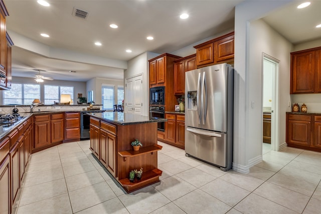 kitchen featuring ceiling fan, a center island, light tile patterned floors, and black appliances