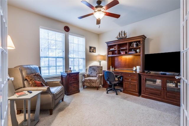 carpeted office space featuring french doors and ceiling fan