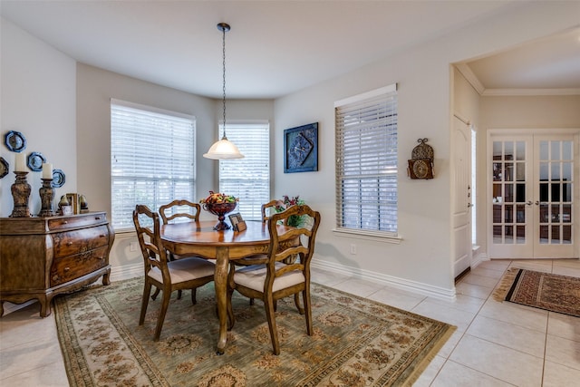 tiled dining room featuring crown molding and french doors