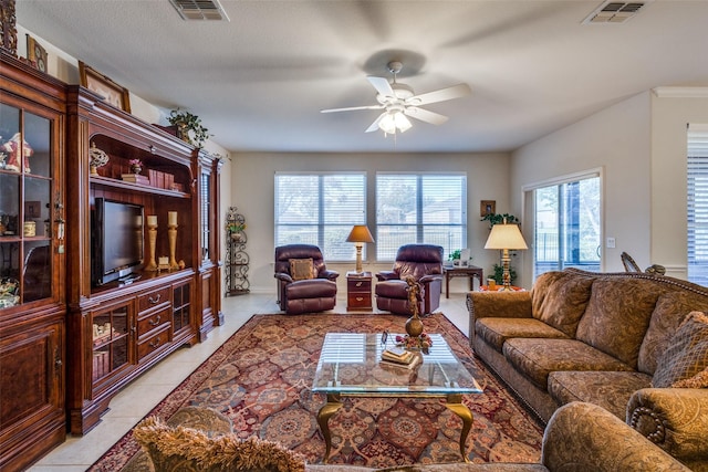 tiled living room with ceiling fan and a textured ceiling