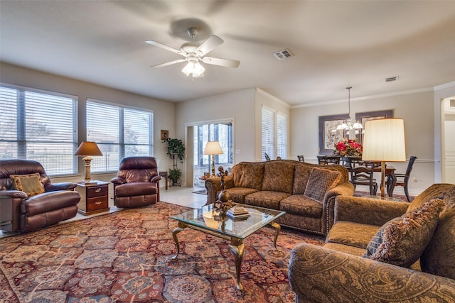 tiled living room with ceiling fan with notable chandelier and ornamental molding