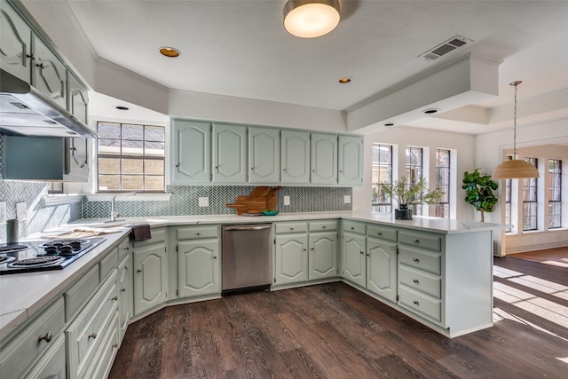 kitchen with backsplash, green cabinetry, dark hardwood / wood-style flooring, kitchen peninsula, and stainless steel appliances