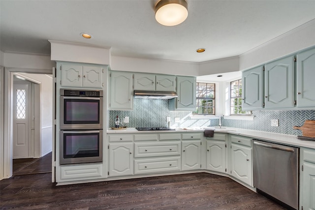 kitchen featuring decorative backsplash, stainless steel appliances, dark hardwood / wood-style floors, and sink