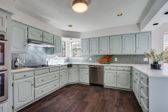 kitchen with decorative backsplash, dark hardwood / wood-style flooring, stainless steel appliances, and crown molding