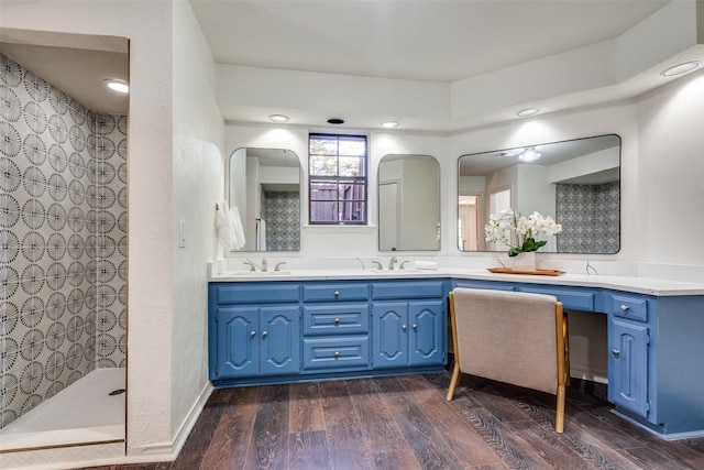 bathroom with a shower, vanity, and wood-type flooring