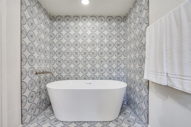 bathroom featuring a bath and tile walls