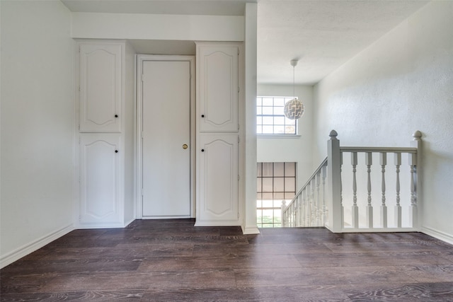 unfurnished room featuring dark hardwood / wood-style floors and a notable chandelier