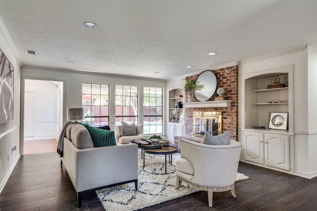 living room with ornamental molding, built in shelves, a textured ceiling, a fireplace, and dark hardwood / wood-style floors