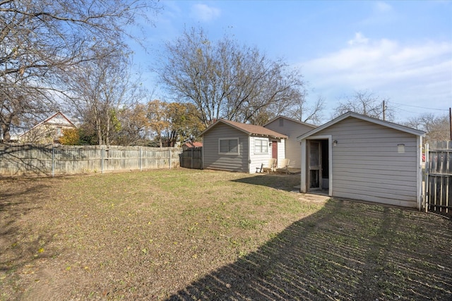 rear view of house featuring a lawn and an outbuilding