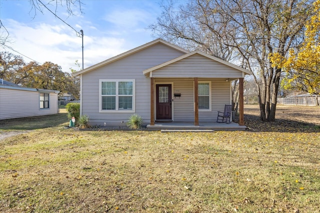 bungalow-style house featuring covered porch and a front lawn