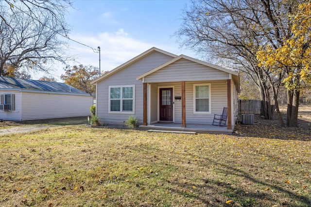 view of front of house featuring covered porch, a front lawn, and central AC unit