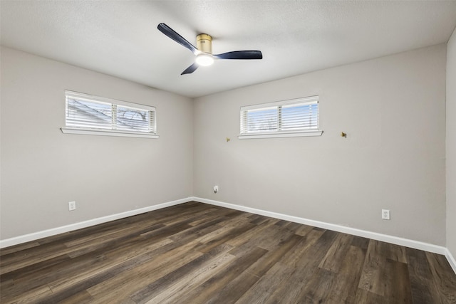 empty room with dark hardwood / wood-style floors, ceiling fan, and a wealth of natural light