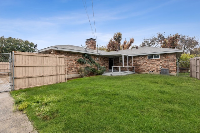 back of property featuring a yard and central AC