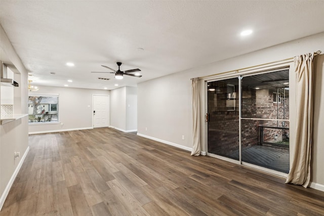 unfurnished living room featuring hardwood / wood-style floors, ceiling fan, and a textured ceiling