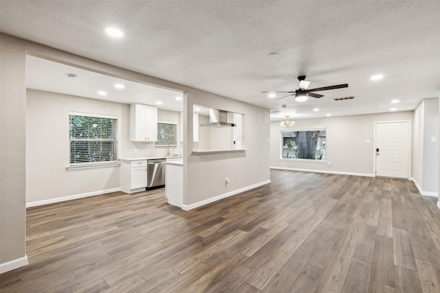 unfurnished living room featuring ceiling fan, sink, a textured ceiling, and light hardwood / wood-style flooring