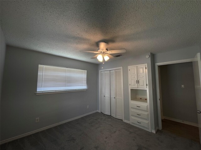 unfurnished bedroom featuring ceiling fan, a textured ceiling, and dark colored carpet