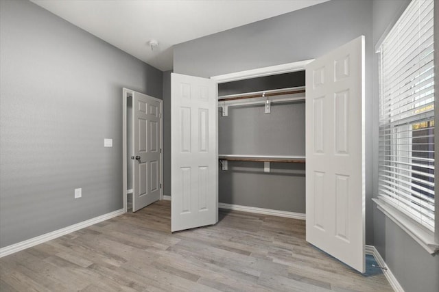 unfurnished bedroom with light hardwood / wood-style floors and a closet